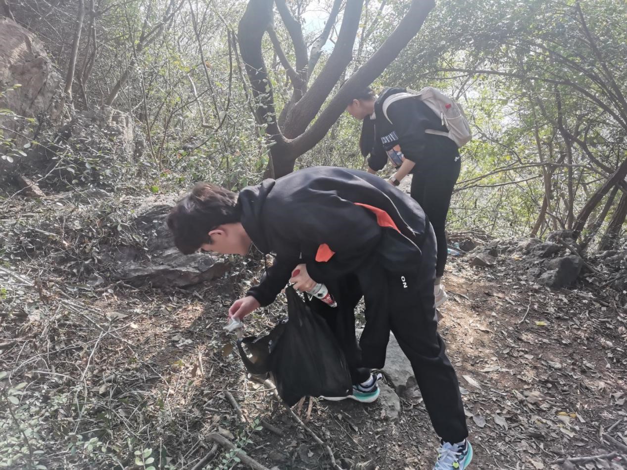 图为同学以及特警们在清理山上的垃圾1.jpg